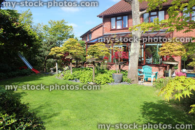 Stock image of modern red brick house and back garden lawn / conservatory