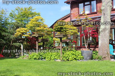 Stock image of sunny south facing garden with green lawn, house, conservatory