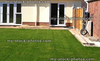 Stock image of back garden with green lawn turf grass, stripes