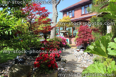 Stock image of oriental garden with stepping stones, pebbles, house conservatory