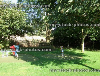 Stock image of young girl playing in woodland playground with trees