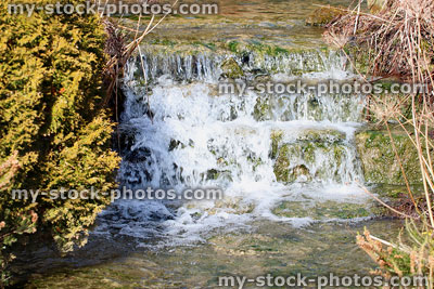 Stock image of man made waterfall and stream in rockery rock garden