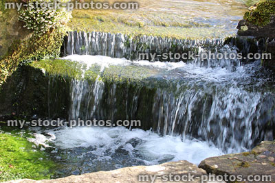 Stock image of waterfall close up, stream flowing over rocks, landscaped rockery garden