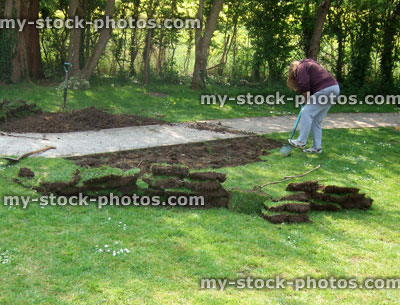 Stock image of woman digging up lawn turf grass in garden