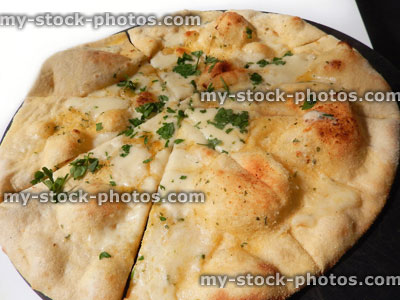 Stock image of garlic bread pizza topped with mozzeralla cheese, herbs