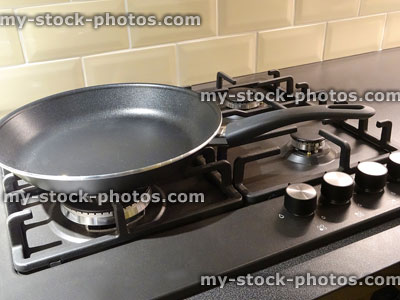 Stock image of non stick frying pan, kitchen gas cooker hob rings