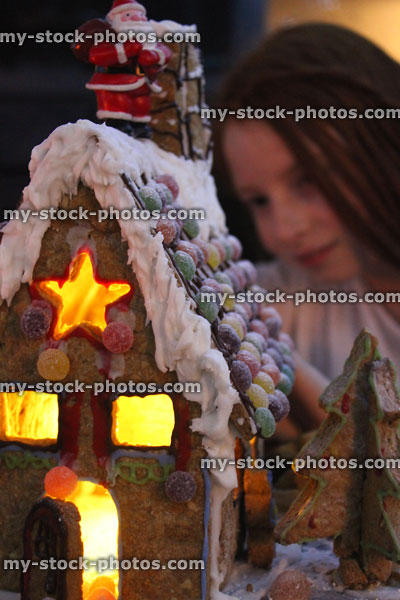 Stock image of young girl with homemade decorated Christmas gingerbread house