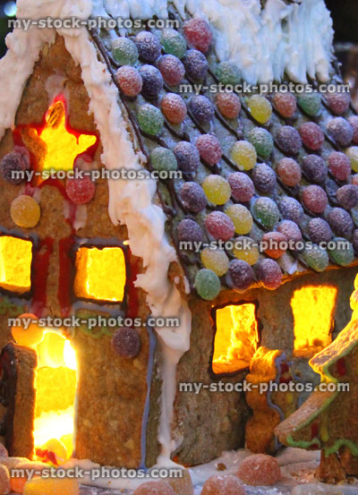 Stock image of homemade iced gingerbread house lit with tealights / candles