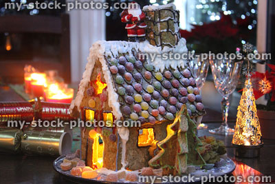 Stock image of decorated gingerbread house at night, lit with Christmas candles