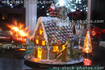 Stock image of Christmas gingerbread house with toy Santa Claus, lit at night