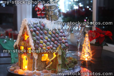 Stock image of small gingerbread house at Christmas time, with nightlight candles