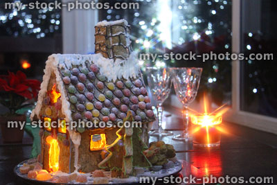 Stock image of decorated Christmas gingerbread house at night, fairy lights and candles