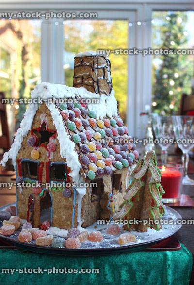 Stock image of gingerbread house on Christmas table runner with sweets