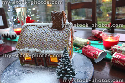 Stock image of biscuit gingerbread house with model Christmas tree, crackers