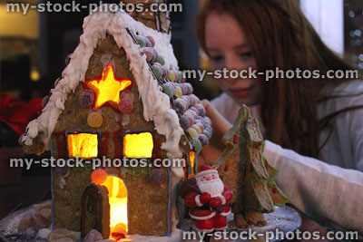 Stock image of biscuit gingerbread house with young girl, Santa Claus