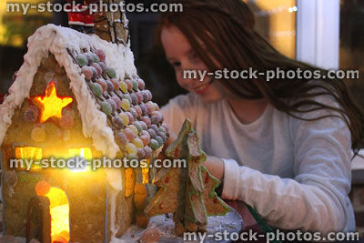 Stock image of girl smiling as she looks at gingerbread house