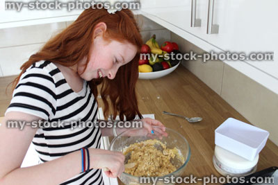 Stock image of young girl baking in kitchen, making biscuits / cookies