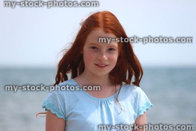 Stock image of girl standing on beach by sea, seaside summer holiday, T shirt