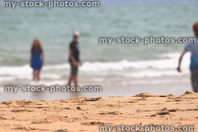 Stock image of children playing / paddling in sea at beach, seaside summer holiday