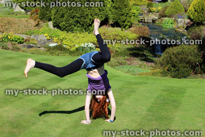 Stock image of girl exercising and doing cartwheels in garden