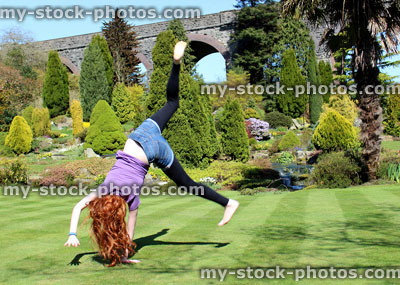 Stock image of girl in middle of doing a cartwheel in garden