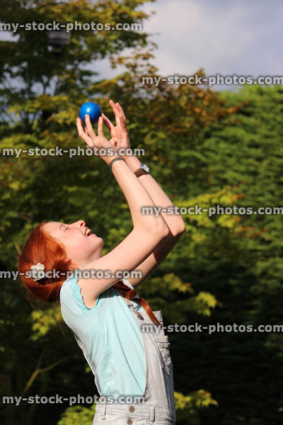 Stock image of girl playing catch in garden, throwing / catching ball