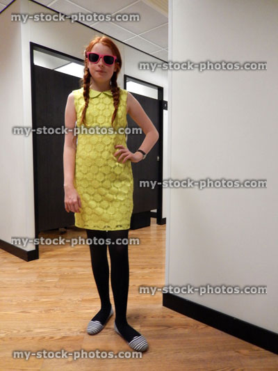 Stock image of girl trying on dress, department store changing rooms, pigtails, sunglasses
