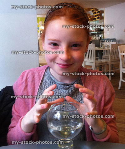 Stock image of red headed girl fortune telling with pretend crystal ball 