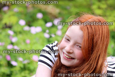 Stock image of pretty, happy girl giggling outside in the garden