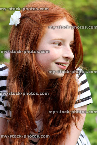 Stock image of attractive, happy girl with long red hair, smiling