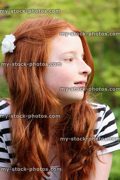 Stock image of beautiful girl with long red hair in garden