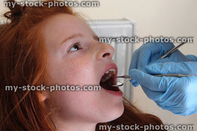 Stock image of girl in dentist chair, toothache, teeth examined, dental appointment