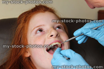 Stock image of girl in dentist chair, toothache, teeth examined, dental appointment