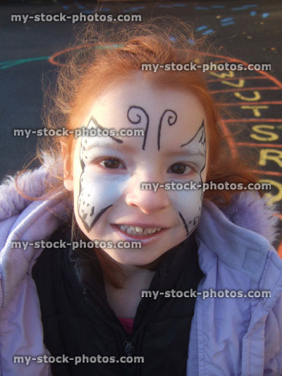 Stock image of little girl with butterfly face paint in playground