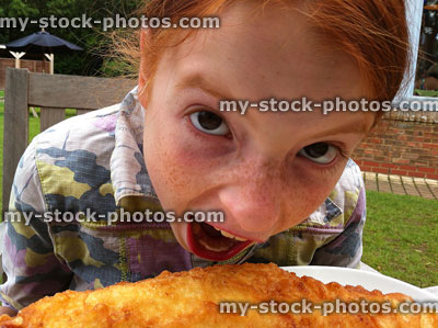 Stock image of young girl eating fish and chips outdoors 