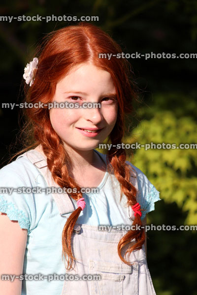 Stock image of young girl with red hair, long pigtails, plaits, braided hair
