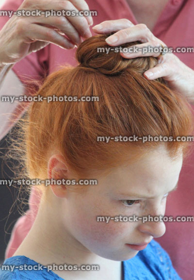 Stock image of girl at hairdresser's, having hair styled in bun