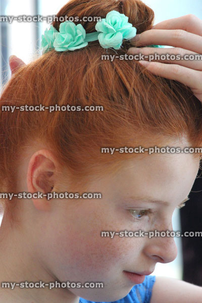 Stock image of girl at hairdresser's, having hair styled in bun