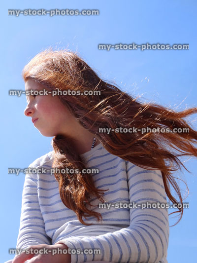 Stock image of girl with long red hair blowing in wind