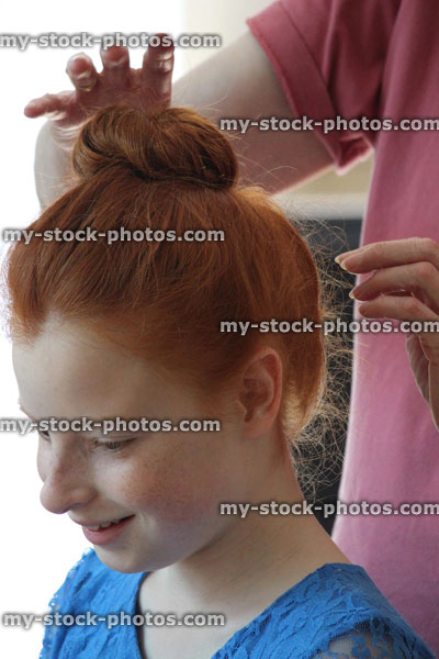 Stock image of girl at hairdresser's, having hair stryled in bun