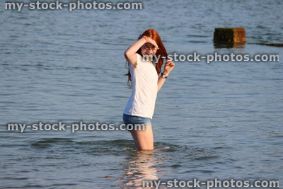 Stock image of girl paddling in sea waves, legs, water, wading, seaside beach<br />
