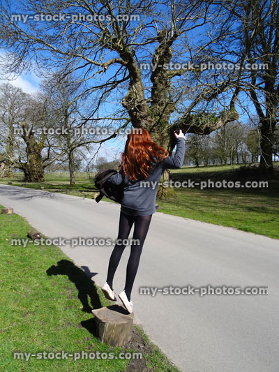 Stock image of teenage girl with long red hair, jumping in air