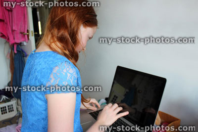 Stock image of girl using laptop computer for school homework, studying in bedroom