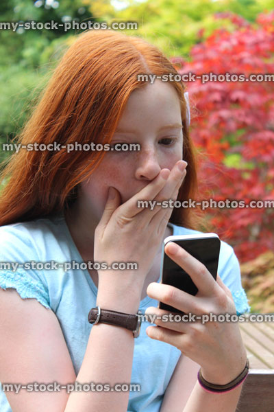 Stock image of girl using mobile phone, speaking, looking shocked, surprised