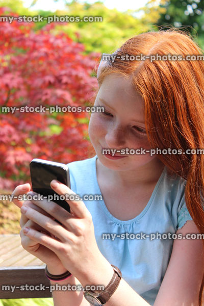 Stock image of girl using mobile phone, speaking, laughing, looking, garden