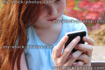 Stock image of girl using mobile phone, speaking, laughing, looking, garden