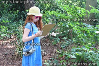 Stock image of girl with clipboard following nature trail / woodland quiz