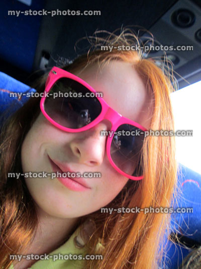 Stock image of girl, long red hair and pink sunglasses, selfie