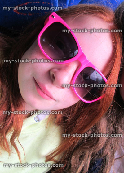 Stock image of girl, long red hair and pink sunglasses, selfie