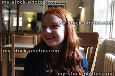 Stock image of young girl with long red hair, laughing, smiling